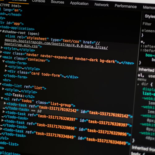 Fotografija monitora sa web razvojnim alatima i HTML kodom